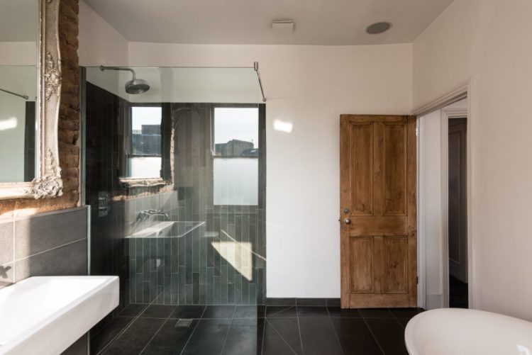 black-and-white-bathroom-with-vintage-door-via-the-modern-house