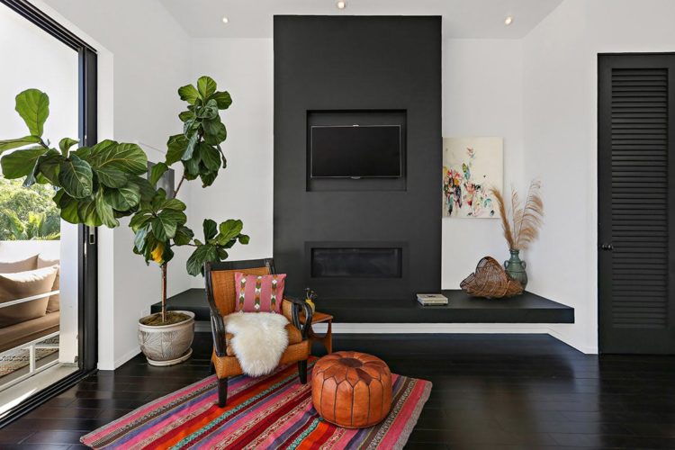 black fire place and fiddle leaf fig