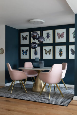 Kate Watson-Smyth uses paint to create a zone or area within an open plan space. the gold dining table base and pink dining chairs make a statement against the rich navy blue gallery wall. #gallerywall #diningroom #openplan #madaboutthehouse