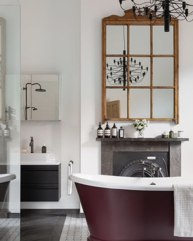 Kate Watson-Smyth takes a look at bathroom design and how to take inspiration and adapt it for your space. A classic background of mostly white but the freestanding bath has been painted in a deep plum colour. And you could change this if you got bored. The black chandelier is the real focal point in this bathroom. #bathroomdesign #freestandingbath #madaboutthehouse