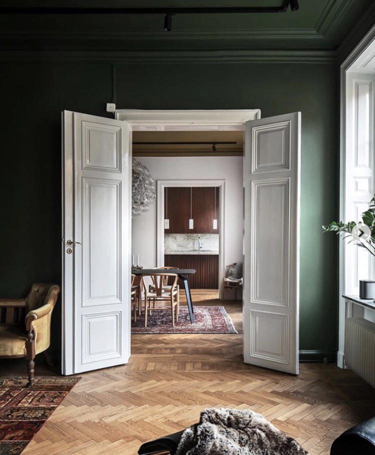 Kate Watson-Smyth takes a look at beautiful rooms with inspirational colour schemes. Here a Stockholm apartment is painted in a forest green on the walls and ceiling with crisp white double doors and paintwork. #doubledoors #madaboutthehouse