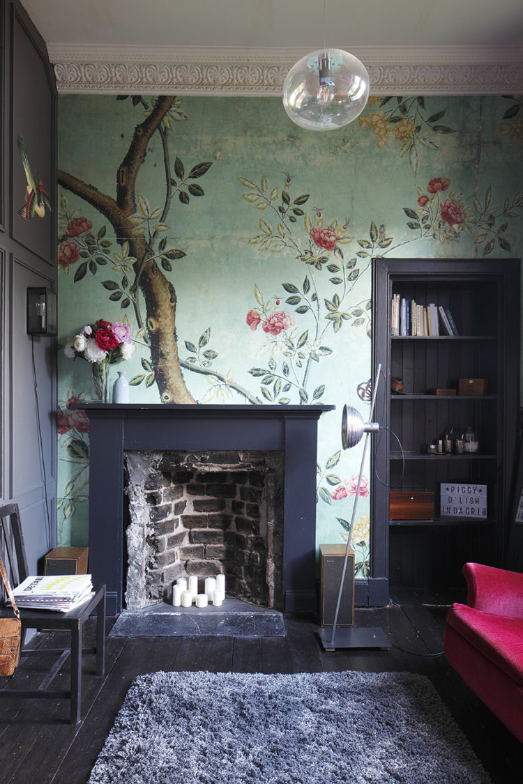 A Victorian living room with black original fireplace. The mint green chinoiserie wallpaper adds a decorative touch. design by architect laura jane clark