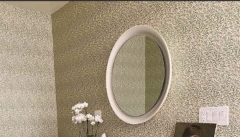 trestle basin vanity by Brigette Romanek in wallpapered bathroom. Large