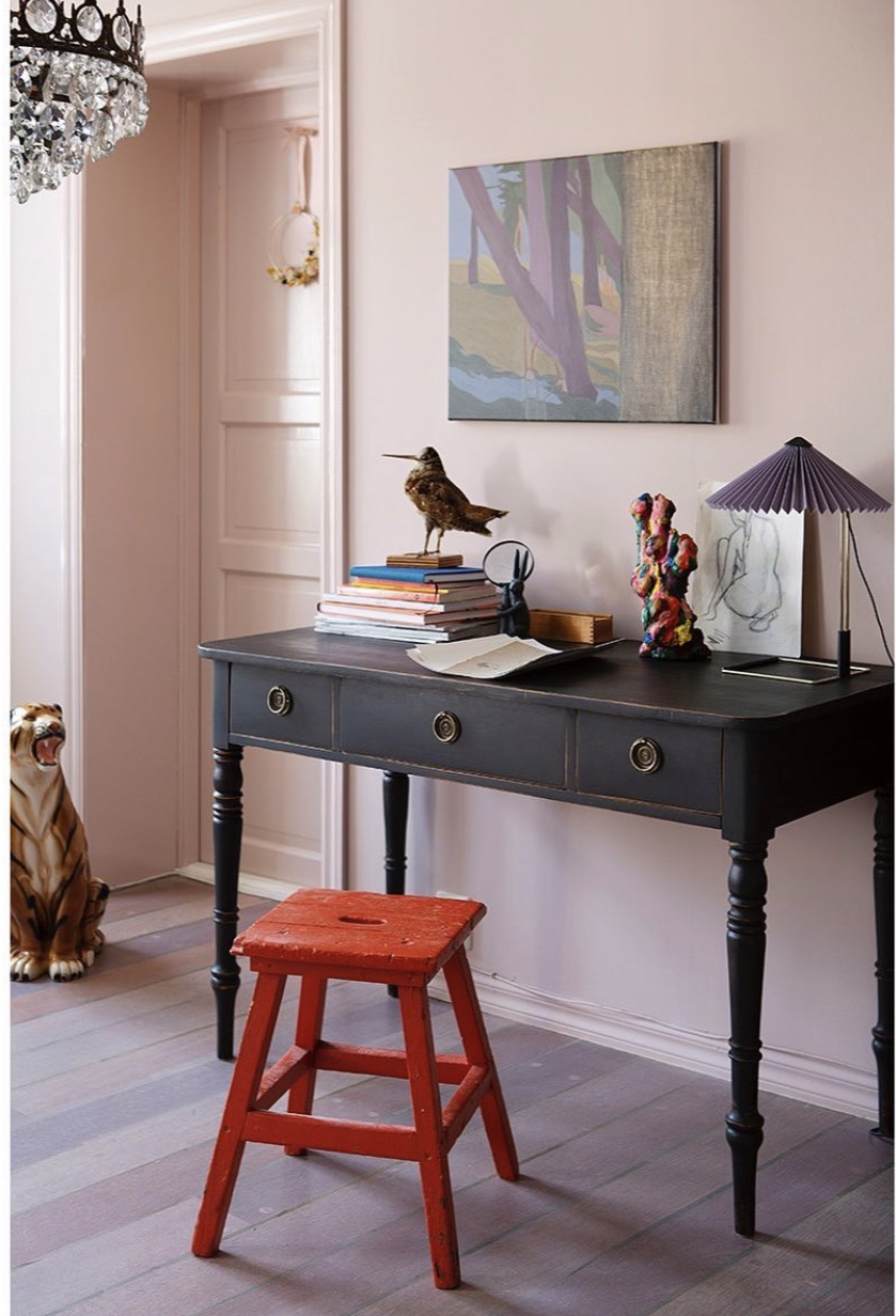Pale pink walls and woodwork, traditional black desk and red painted wooden stool. image via les filles des fleurs image by anneline bakken
