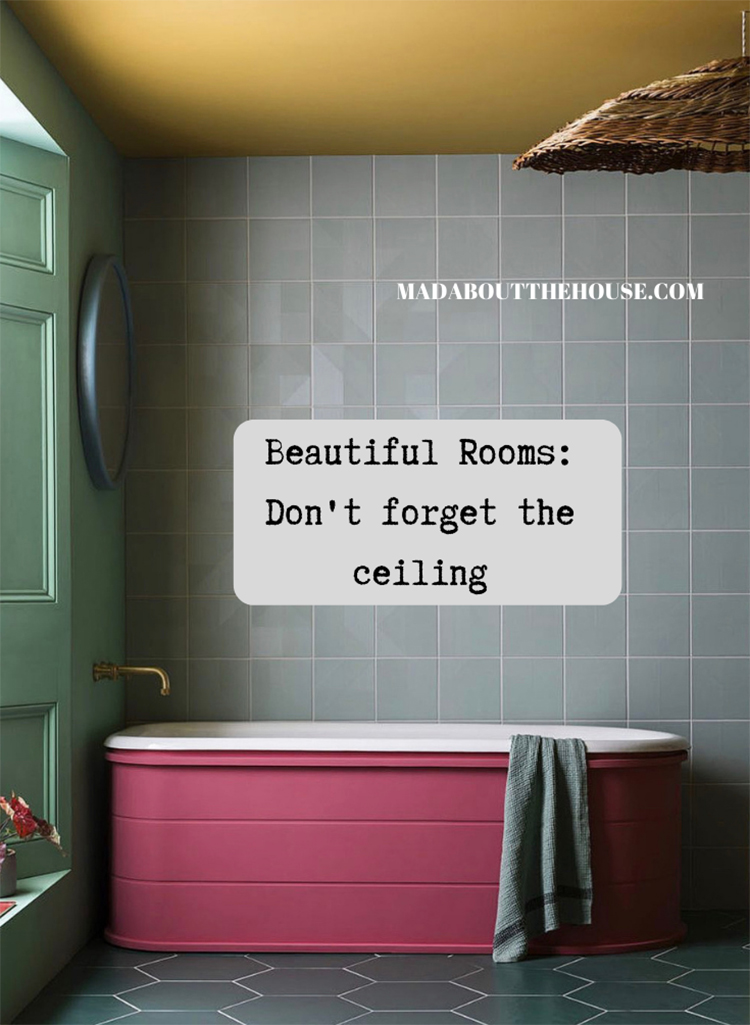 Yellow painted bathroom ceiling with pink bath and grey hexagonal floor tiles