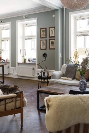 Open plan living dining, dark parquet floor, dark wood coffee table pale blue walls via historika hem. Madaboutthehouse.com